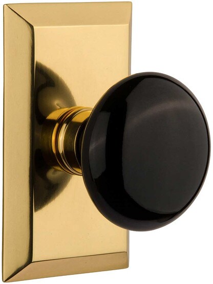 New York Rosette Door Set with Black Porcelain Knobs in Polished Brass.